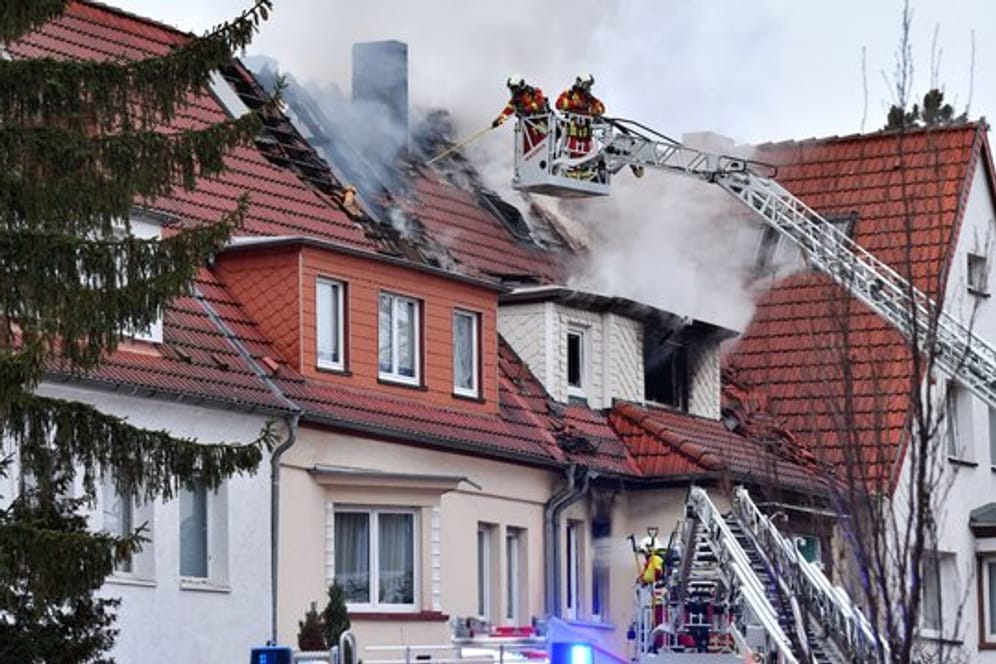 Feuerwehrleute bekämpfen einen Wohnhausbrand