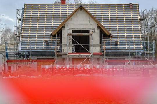 Ein Haus wird gebaut: Der Bau eines Eigenheims kann durch den Grund, auf dem das Gebäude stehen soll, entscheidend beeinflusst werden.