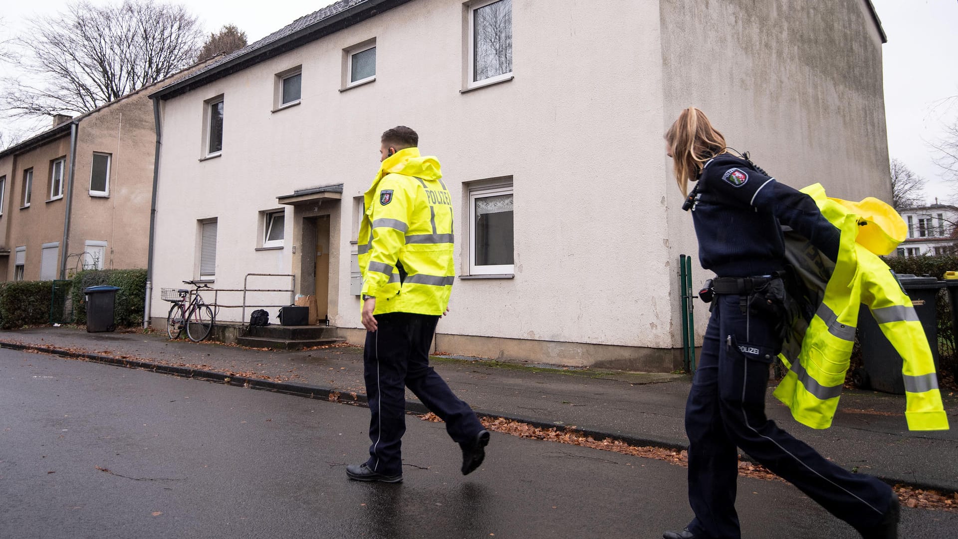 Zwei Polizisten vor einem Wohnhaus in Köln-Dünnwald: Ein Bewohner hat zwei Mitarbeiter der Stadt mit einem Messer angegriffen und einen dabei tödlich verletzt.