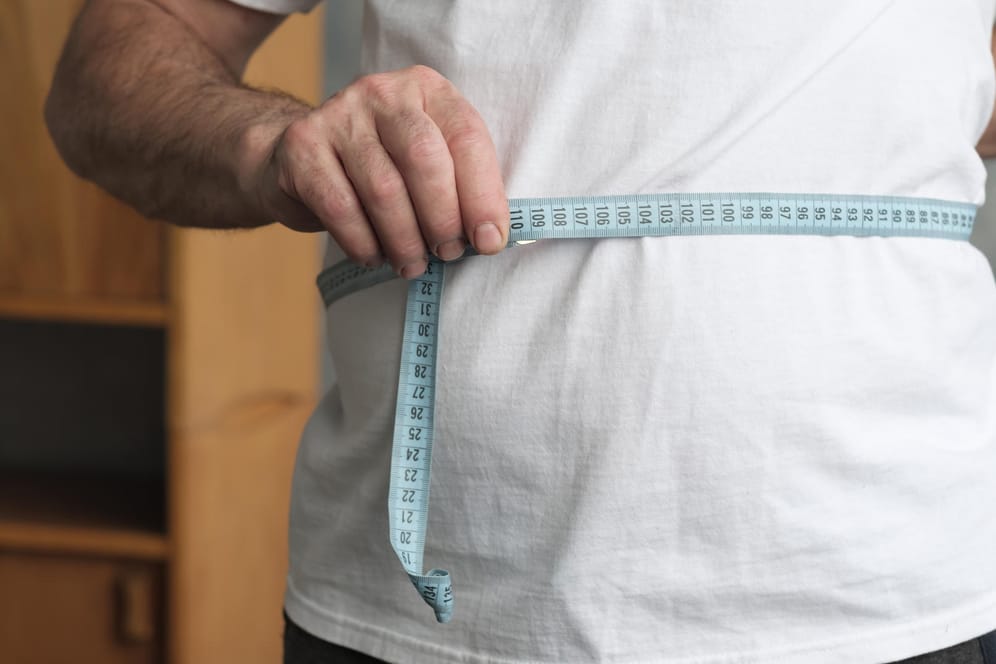 Ein Mann misst seinen Bauchumfang: Fettzellen können dafür sorgen, dass schädliche Hormone und Botenstoffe im Körper freigesetzt werden.
