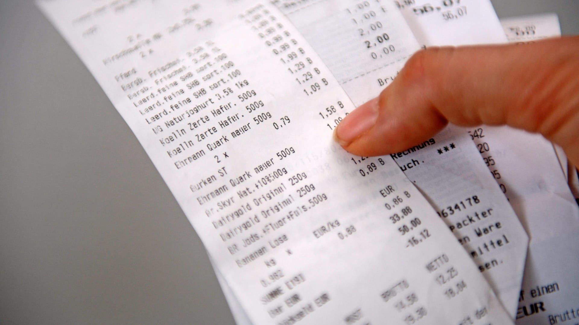 Eine Person hält Kassenzettel in der Hand: Rewe setzt nach eigenen Angaben seit 2012 nur noch phenolfreies Papier ein. Eine Person hält Kassenzettel in der Hand: Rewe setzt nach eigenen Angaben seit 2012 nur noch phenolfreies Papier ein.