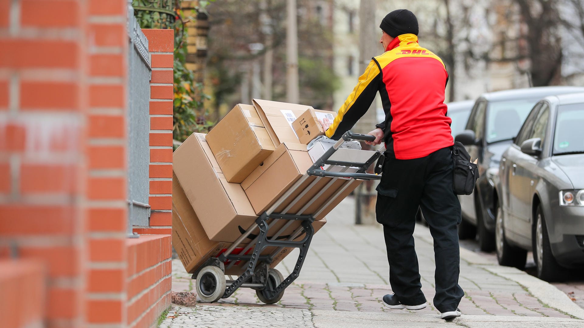 DHL Paketzusteller mit einer Sackkarre: DHL rechnet für die Tage vor Weihnachten mit einem neuen Rekord von Paketzahlen. Das wirkt sich auf die Transportkosten aus. DHL Paketzusteller mit einer Sackkarre: DHL rechnet für die Tage vor Weihnachten mit einem neuen Rekord von Paketzahlen. Das wirkt sich auf die Transportkosten aus.