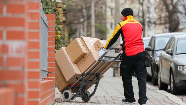 Ein DHL Paketzusteller bei der Arbeit.