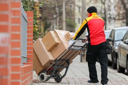 Ein DHL Paketzusteller bei der Arbeit.