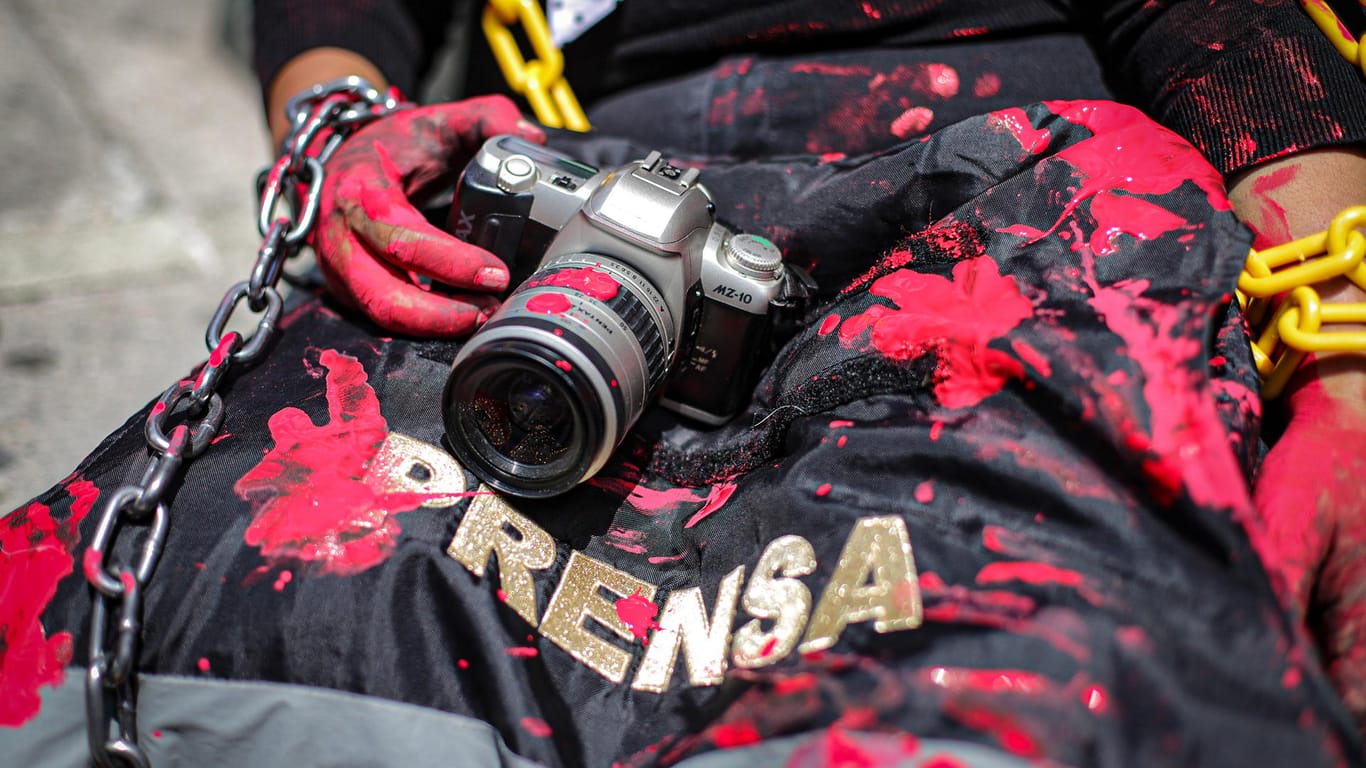 Eine mexikanische Journalistin hält eine rot verschmierte Kamera und eine Presseweste: Für Journalisten war Mexiko 2019 genauso gefährlich wie das Bürgerkriegsland Syrien.