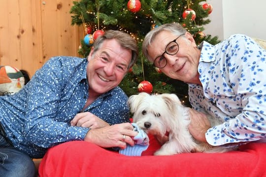 Patrick Lindner (l) und sein Lebensgefährte Peter Schäfer mit ihrem Hund Obelix.