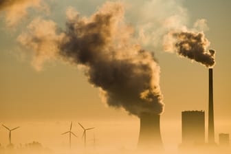 Ein Kohlekraftwerk und Windräder: Der CO2-Preis soll im Verkehr und bei Gebäuden schrittweise bis 2025 erhöht werden