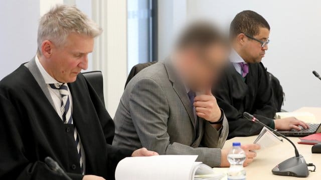 Der angeklagte Neurochirurg (M) mit seinen Anwälten im Rostocker Landgericht. Der angeklagte Neurochirurg (M) mit seinen Anwälten im Rostocker Landgericht.