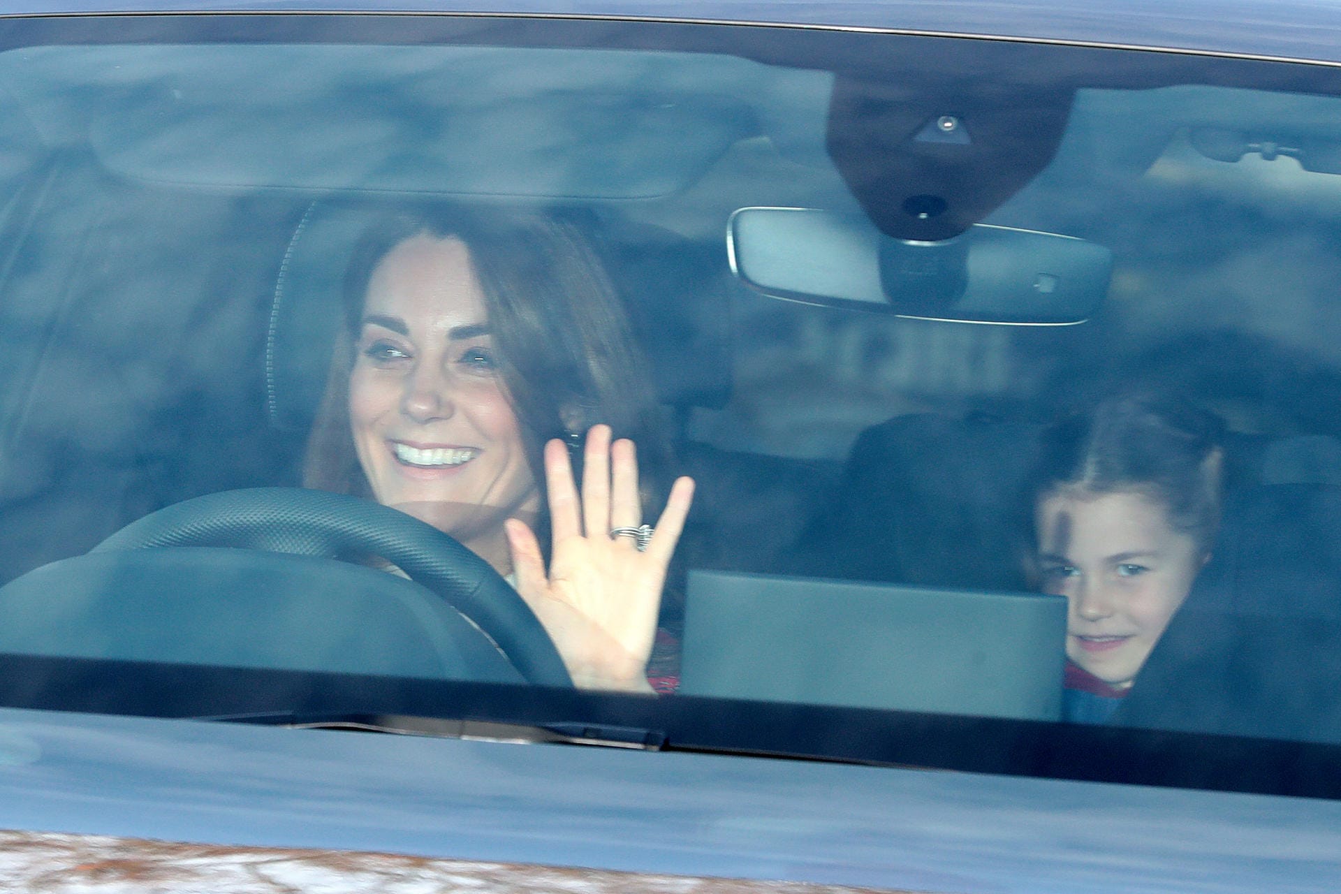 Kate fährt zum Weihnachtsessen: Die Herzogin von Cambridge winkt, Prinzessin Charlotte sitzt auf dem Rücksitz.
