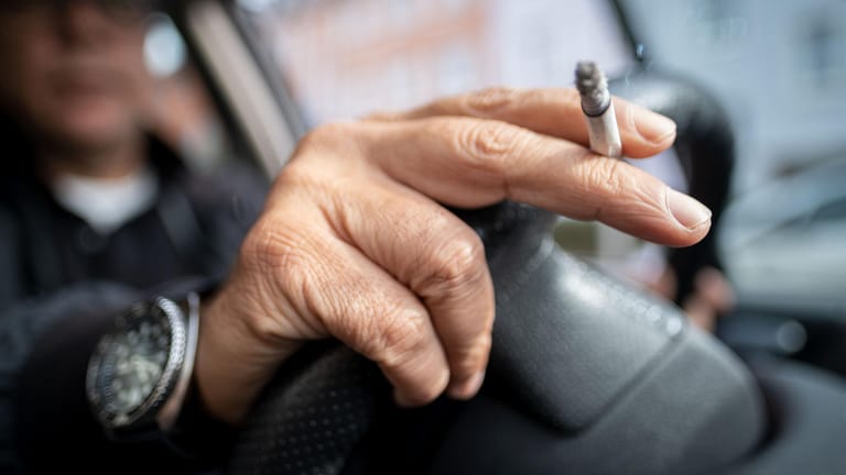 Ein Mann sitzt rauchend am Lenkrad eines Autos: Der Tabakkonsum bei Männern sinkt – nicht aber bei männlichen Rauchern.