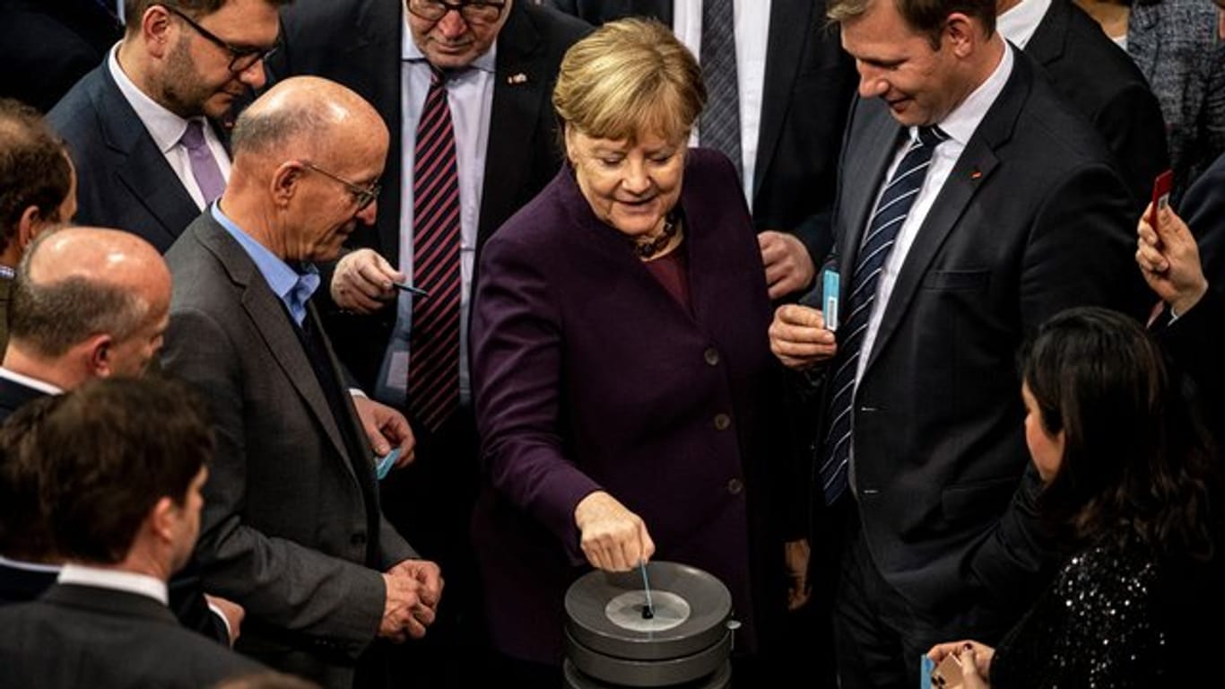 Kanzlerin Angela Merkel und Abgeordnete bei der Abstimmung im Bundestag.