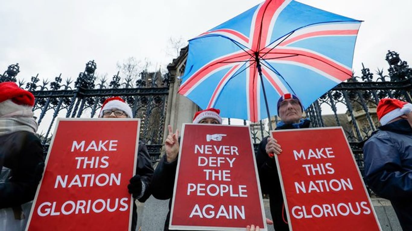 Befürworter des Brexit halten Plakate mit den Aufschriften "Never defy the people again" (Bietet den Bürgern nie wieder die Stirn) und "Make this nation glorious" (Macht diese Nation prächtig) vor dem britischen Parlament.