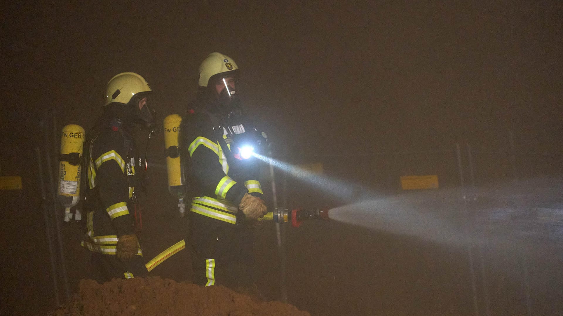 Feuerwehrmänner nach der Sprengung der Bombe: Die Feuerwehr stellte zur Sicherheit Wasserwerfer auf, um die Gefahr durch möglichen Phosphornebel zu verkleinern.