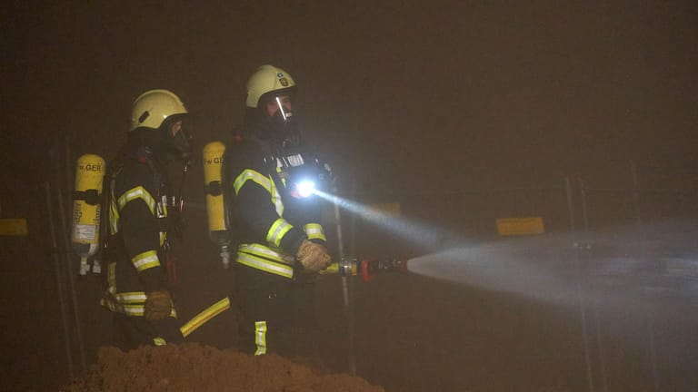 Feuerwehrmänner nach der Sprengung der Bombe: Die Feuerwehr stellte zur Sicherheit Wasserwerfer auf, um die Gefahr durch möglichen Phosphornebel zu verkleinern.