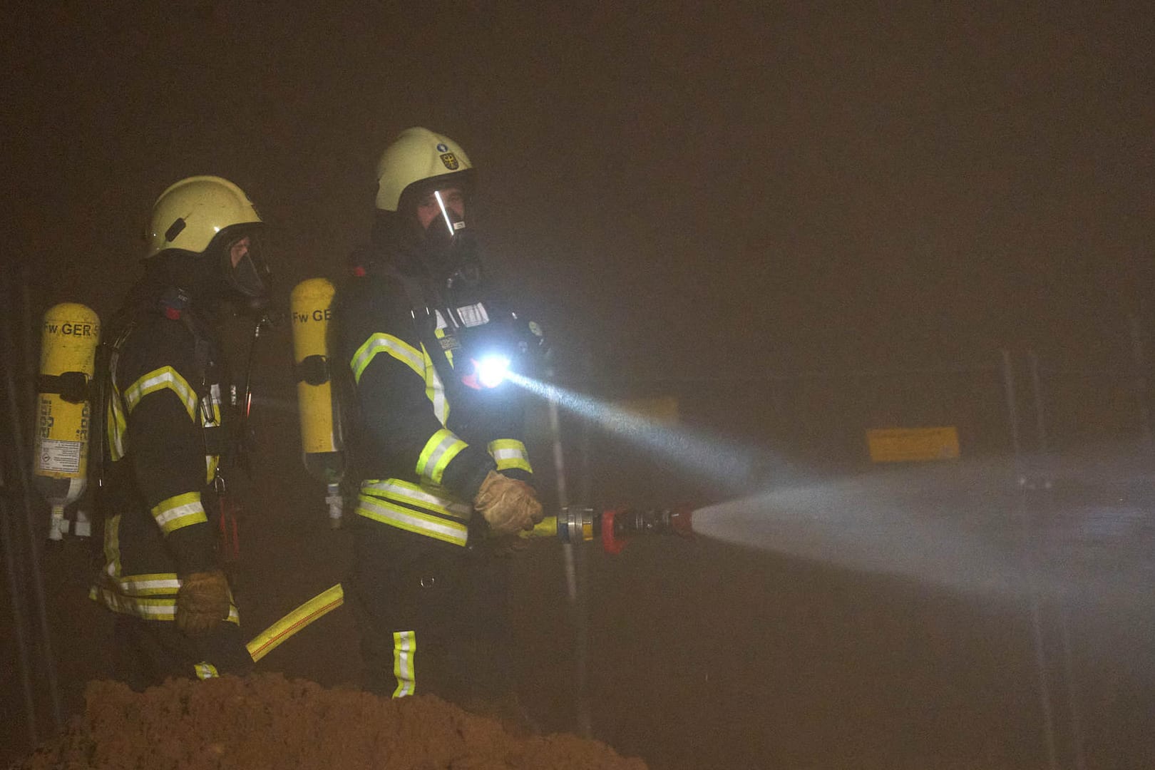 Feuerwehrmänner nach der Sprengung der Bombe: Die Feuerwehr stellte zur Sicherheit Wasserwerfer auf, um die Gefahr durch möglichen Phosphornebel zu verkleinern.