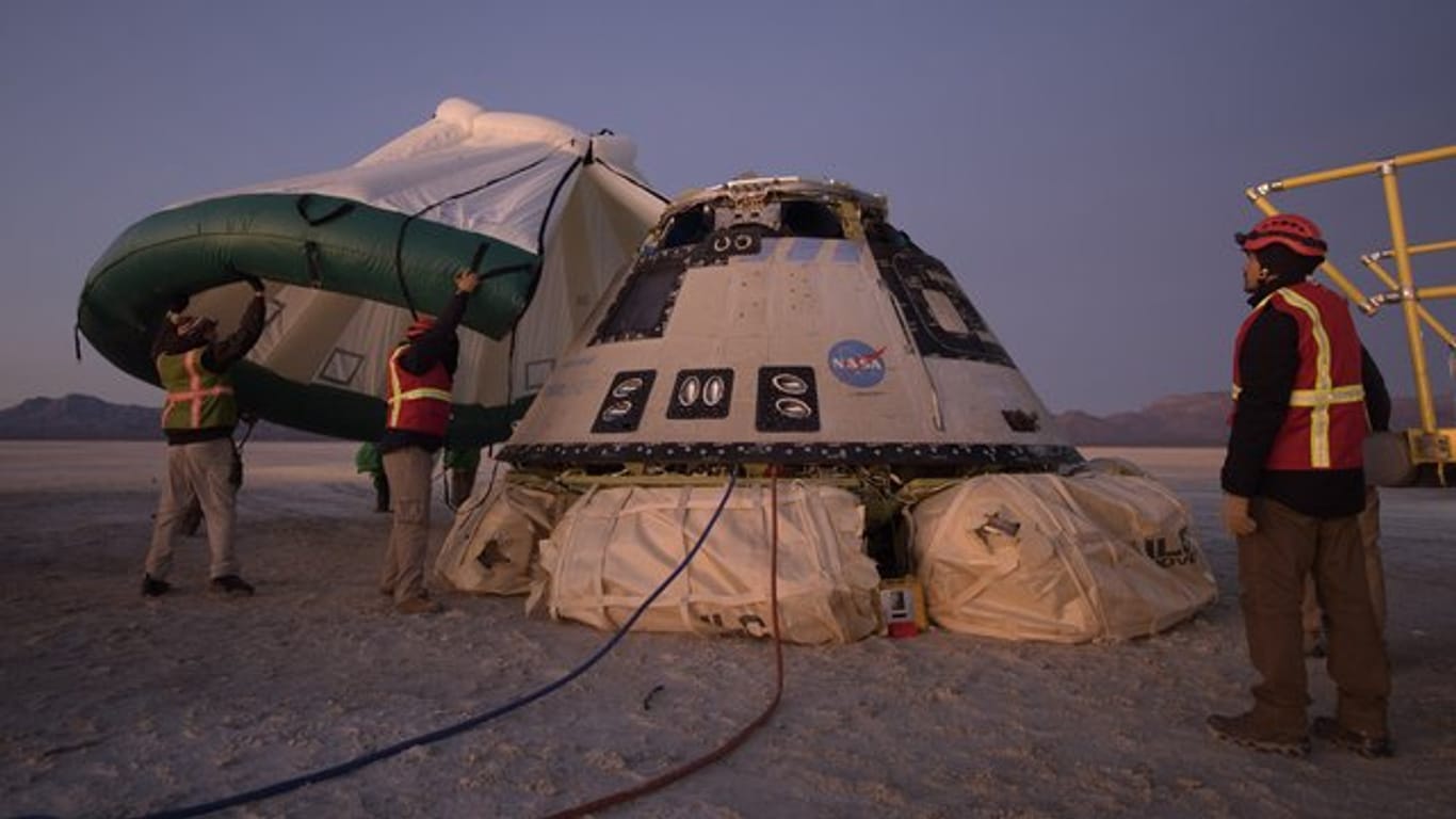 Mitarbeiter von Boeing, NASA und der US-Armee inspizieren die "Starliner"-Kapsel nach deren Landung in der Wüste von New Mexico.