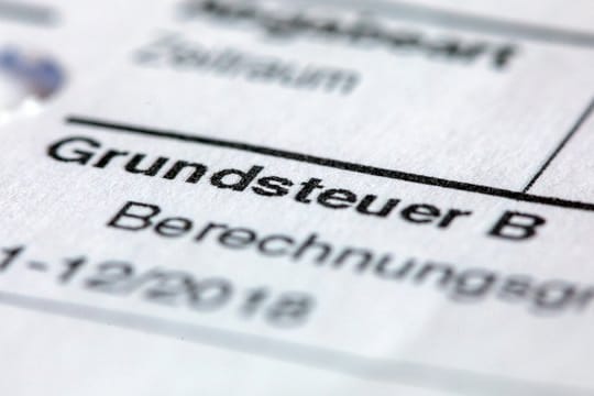 Ein Abgabenbescheid für die Entrichtung der Grundsteuer liegt auf einem Schreibtisch.