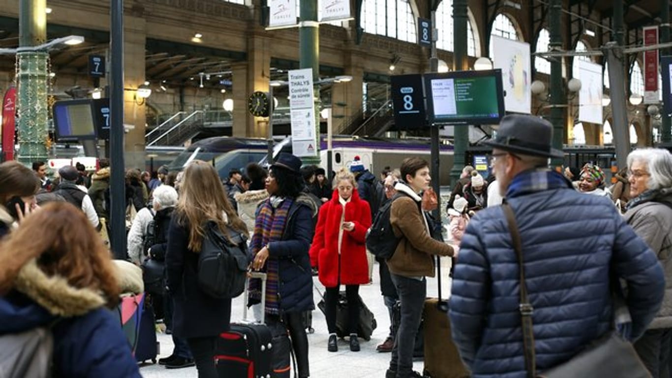Menschen warten am Bahnhof Paris-Nord auf ihre Züge.