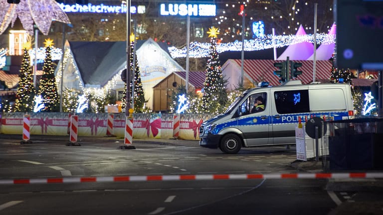 Polizisten sitzen in einem Polizeiauto an dem geräumten Berliner Weihnachtsmarkt: Nach Hinweisen auf einen möglicherweise verdächtigen Gegenstand hat die Polizei am Samstagabend den Breitscheidplatz an der Gedächtniskirche abgesperrt.
