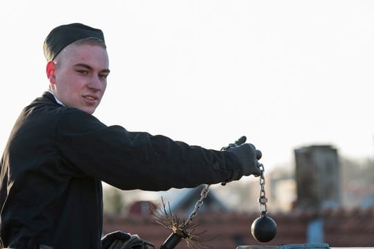 Einen Schornstein mit dem Kaminbesen kehren: Das gehört zu den klassischen Tätigkeiten in der Ausbildung zum Schornsteinfeger.