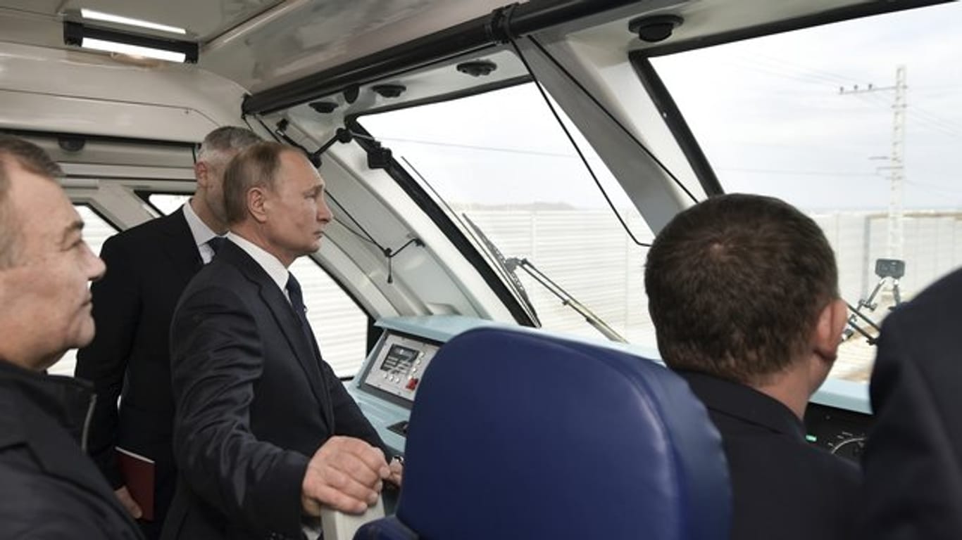 Im Führerstand: Wladimir Putin fährt per Zug über die neue 19 Kilometer lange Brücke, die die Krim mit dem russischen Festland verbindet.
