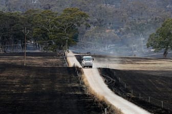 Australien nach den Bränden: Ein Fahrzeug der Feuerwehr fährt durch abgebrannte Felder.