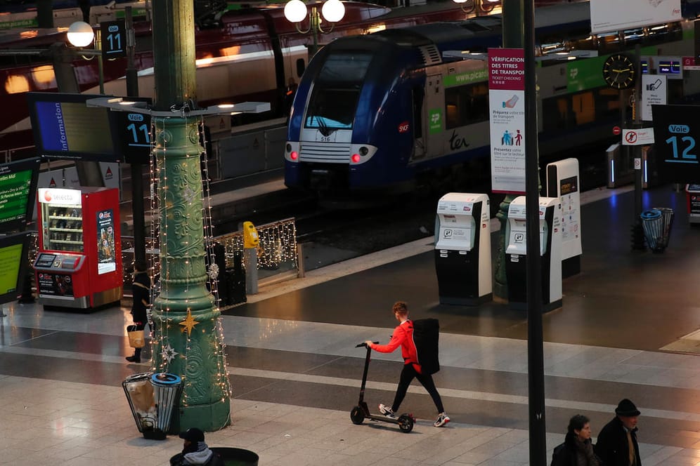 Paris: Reisende gehen mit ihrem Gepäck durch den Bahnhof Gare du Nord. Wegen andauernder Streiks gegen die Rentenreform, müssen sich Reisende auf erhebliche Behinderungen in Nah- und Fernverkehr einstellen.