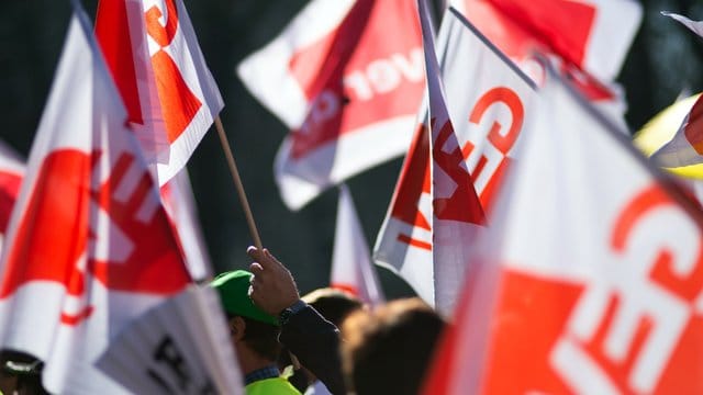 Teilnehmer eines Warnstreiks im öffentlichen Dienst schwenken Gewerkschaftsfahnen von GEW und Verdi. Teilnehmer eines Warnstreiks im öffentlichen Dienst schwenken Gewerkschaftsfahnen von GEW und Verdi.