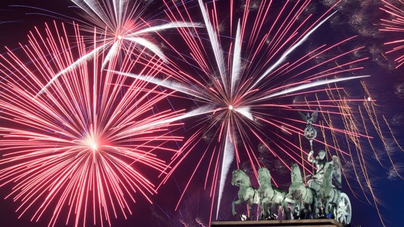 Feuerwerk während der größten Silvesterparty Deutschlands hinter dem Brandenburger Tor.
