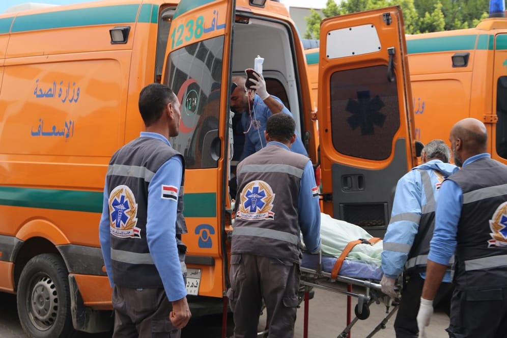 Schweres Unglück in Ägypten: Sanitäter bringen einen Verletzten in einen Krankenwagen.