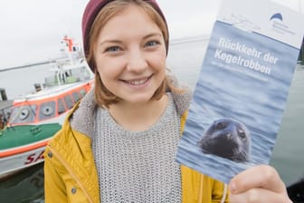 Linda Westphal, Meeresbiologin am Deutschen Meeresmuseum,zeigt eine Broschüre zur Rückkehr der Kegelrobben in der Ostsee.