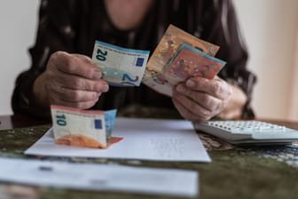 Eine Frau zählt Geld: Werden die Deutschen bald noch länger arbeiten müssen, um ihre Rente zu sichern?