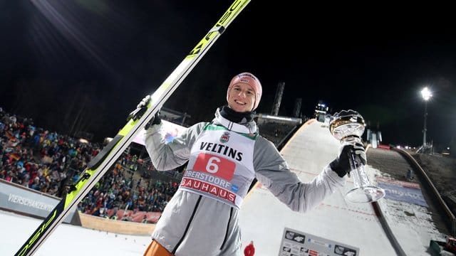 Karl Geiger jubelt mit dem silbernen Pokal für seinen zweiten Platz.