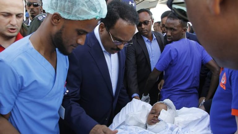 Somalias Präsident Mohamed Abdullahi Mohamed (Mitte l) besucht Opfer, die bei der Explosion einer Autobombe am 28.