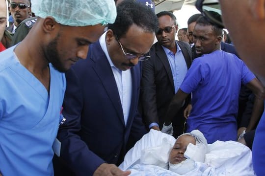 Somalias Präsident Mohamed Abdullahi Mohamed (Mitte l) besucht Opfer, die bei der Explosion einer Autobombe am 28.