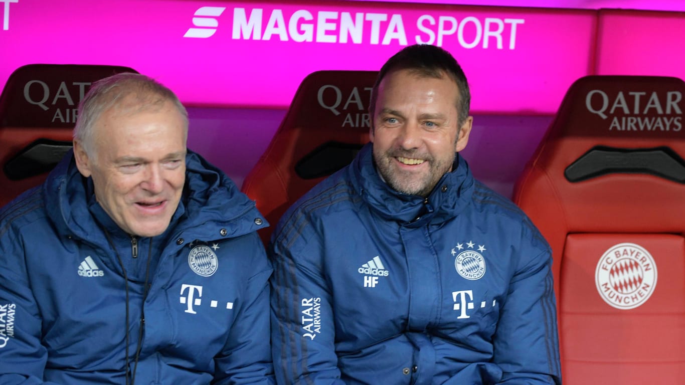 Fühlt sich als Cheftrainer des Rekordmeister sehr wohl: Hansi Flick (r.), der auf diesem Bild neben Hermann Gerland sitzt.