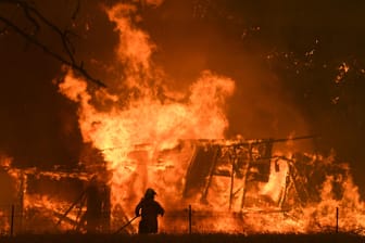 Ein Feuerwehrmann vor einem brennenden Haus in New South Wales, Australien: Die Flammen schlagen bis zu 20 Meter hoch.