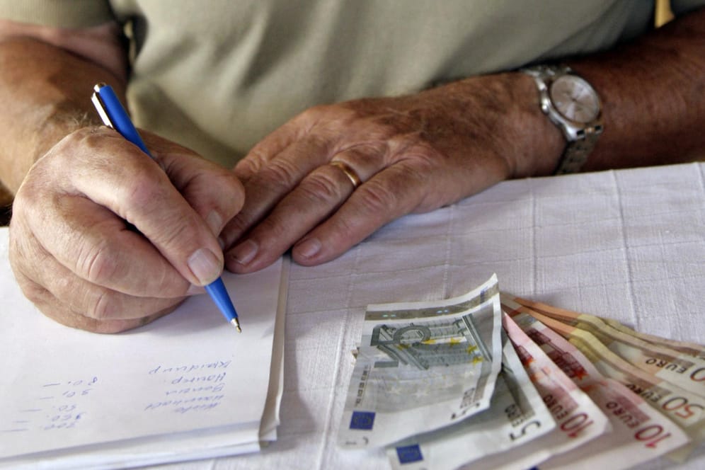 Ein Rentner macht sich auf einem Block Notizen seiner Geldausgaben: Viele Senioren müssen mit ihrer Rente genau haushalten, um über die Runden zu kommen.