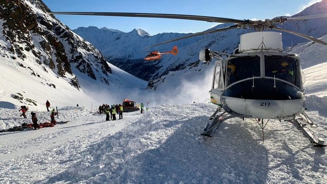 Ein Helikopter ist während einer Suchaktion von Rettungskräften nach einer Lawine auf einer Skipiste gelandet. Ein Helikopter ist während einer Suchaktion von Rettungskräften nach einer Lawine auf einer Skipiste gelandet.