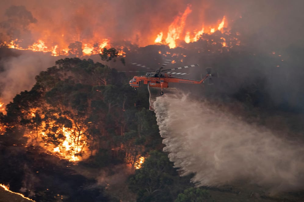 Ein Löschhubschrauber bekämpft das Buschfeuer im Bundesstaat Victoria: Die Marine soll den Tausend eingeschlossenen in Ostaustralien helfen.