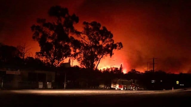 Flammen färben den Himmel bei einem Buschfeuer in der Nähe von Nowa Nowa, East Gippsland, rot. Flammen färben den Himmel bei einem Buschfeuer in der Nähe von Nowa Nowa, East Gippsland, rot.