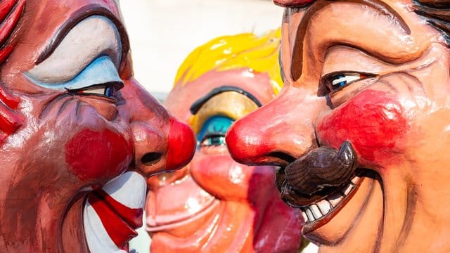 Zwei Mainzer Schwellköppe schauen sich beim Umzug an.