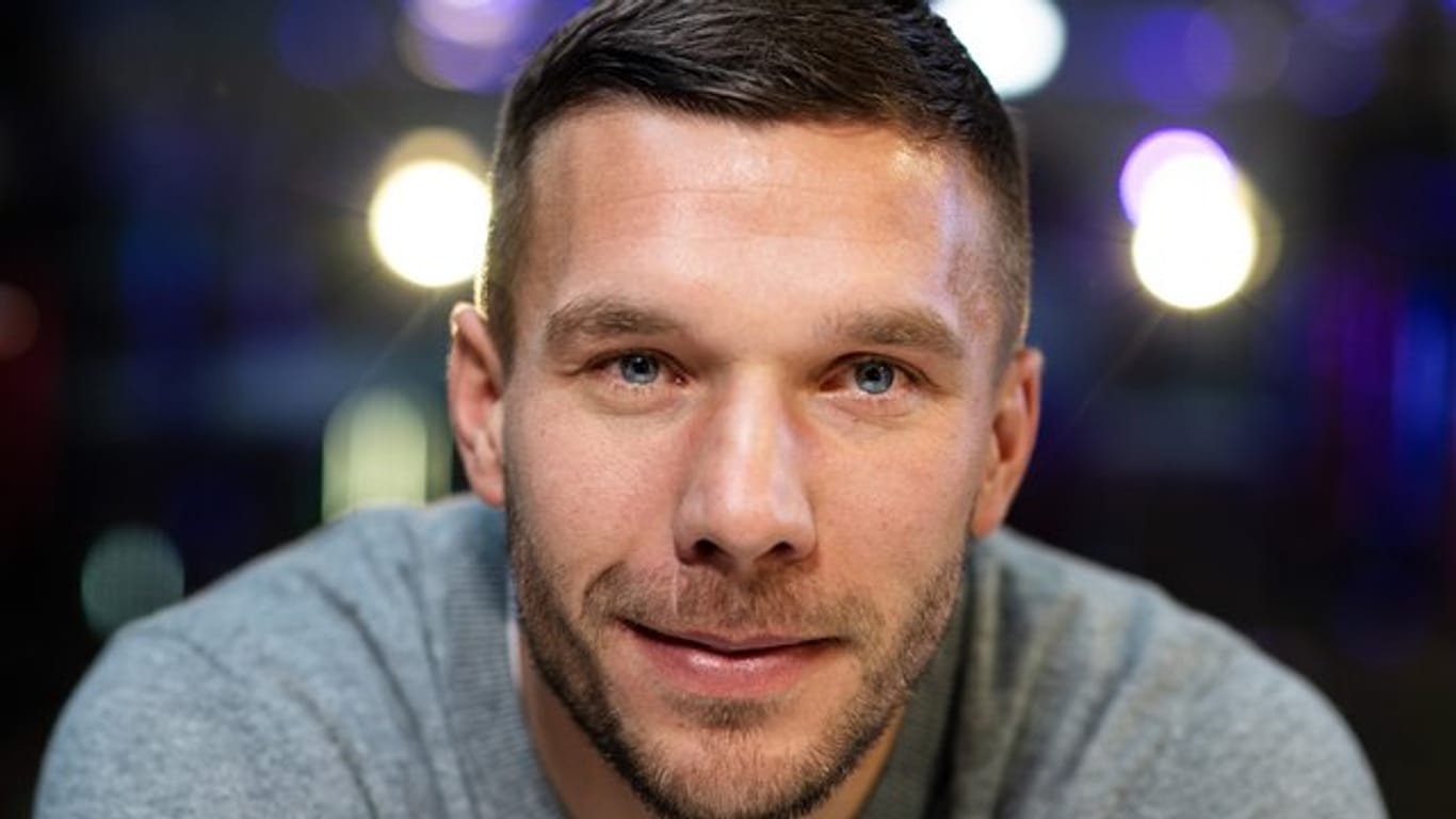 Der frühere Fußball-Nationalspieler Lukas Podolski lächelt: Medien berichten über Gespräche mit dem 1. FC Köln.