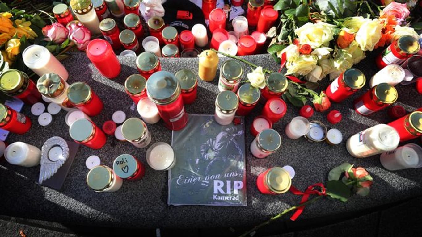 Kerzen und Blumen erinnern in Augsburg an den getöteten Feuerwehrmann.