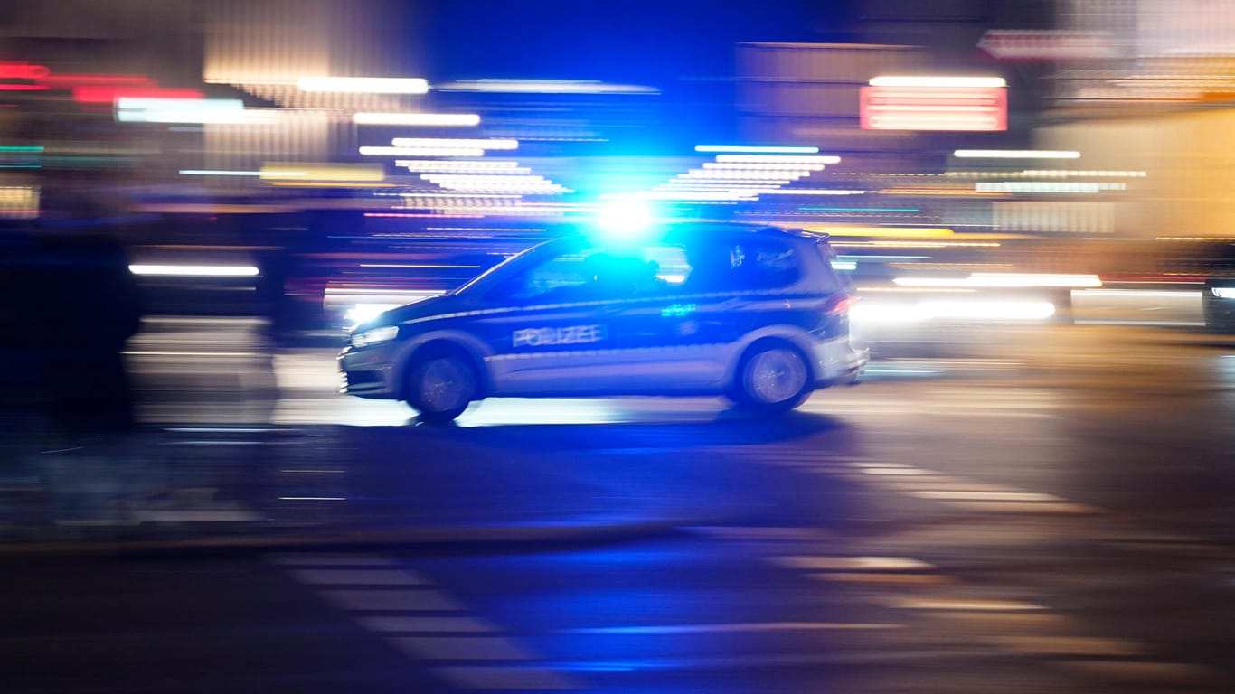 Ein Polizeiauto mit Blaulicht in der Silvesternacht (Symbolbild): In Bonn sind Polizisten gezielt von Feiernden angegriffen worden.