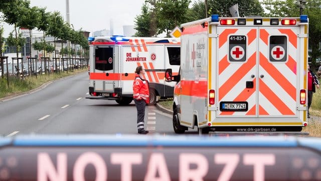Rettungswagen und Notärzte zur Versorgung von Verletzten stehen bei einem Großbrand auf der Straße. Rettungswagen und Notärzte zur Versorgung von Verletzten stehen bei einem Großbrand auf der Straße.