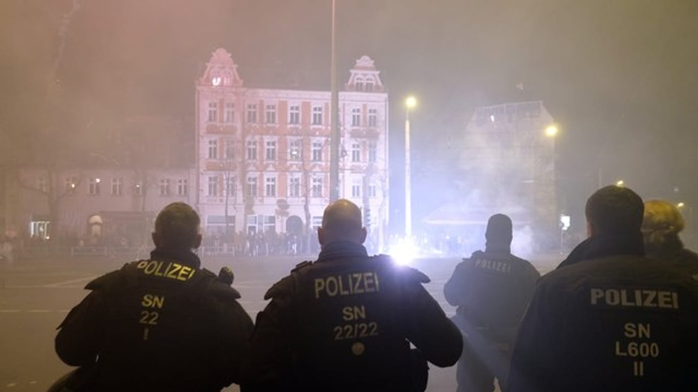 Polizisten stehen in der Neujahrsnacht an einer Kreuzung im Leipziger Stadtteil Connewitz.