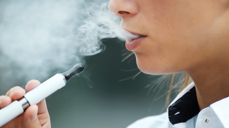 Frau raucht: In Deutschland ist die Zusammensetzung der Wirkstoffe von E-Zigaretten strenger reguliert als in den USA.