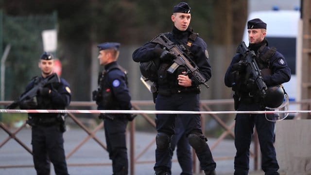 Schwerbewaffnete Polizisten sichern den Tatort nach der Messerattacke.