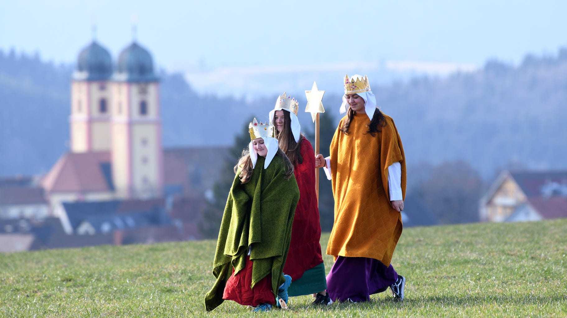 Sternsinger laufen über eine Wiese: Die diesjährige Spendenaktion steht unter dem Motto "Frieden! Libanon und weltweit".